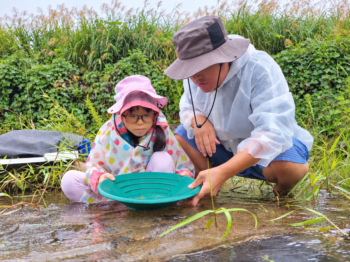 雨具を着て親子でパンニングを体験する様子